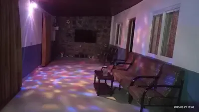 a living room with a couch and a tv at Varshinicottage kothkiri in Kotagiri