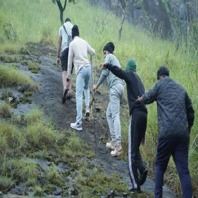 a group of people walking down a trail at Wooden creek tent camping in Meppādi