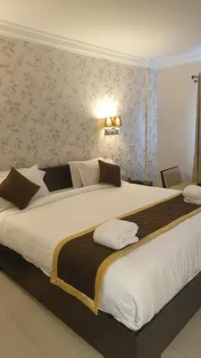 a large bed in a hotel room with a large white bed at Hotel Grand Regency, Angamaly in Angamali