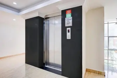 a elevator in a building with a black wall at Hotel Grand Regency, Angamaly in Angamali