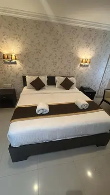 a bedroom with a large bed with two pillows at Hotel Grand Regency, Angamaly in Angamali