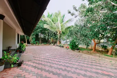 a red brick walkway with plants and trees at San WAYANAD HOMESTAY AND SERVICE VILLA in Sultan Bathery