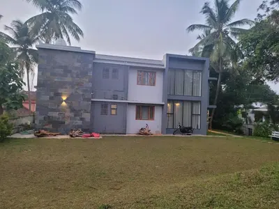 a house with a large yard in front of it at Aurora The Pool Villa ll in Kozhikode
