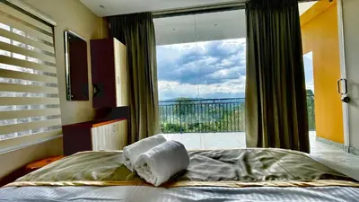 a bedroom with a bed in front of a large window at Elegant Mountain Resort in Kalpetta