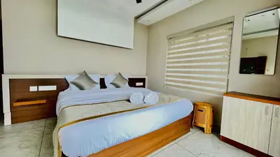 a bedroom with a large bed and a window at Elegant Mountain Resort in Kalpetta