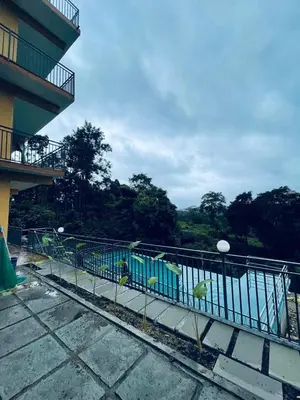 a group of birds sitting on a railing on a building at Elegant Mountain Resort in Kalpetta