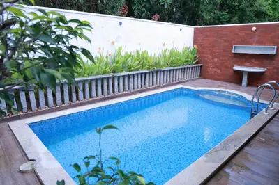 a swimming pool in a backyard with a fence at Hortus Malabaricus Garden Resort in Cheruthuruthi
