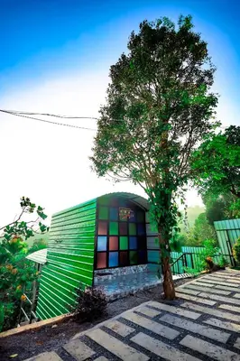 a building with a tree in front of it at La Vista Resorts in Wayanad