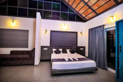 a bedroom with a large bed and a couch at La Vista Resorts in Wayanad