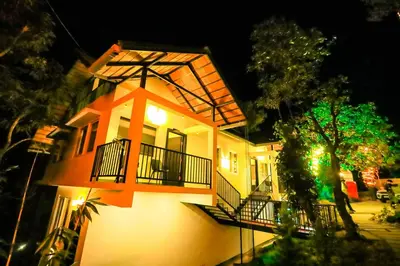 a house with a cross on top of it at night at La Vista Resorts in Wayanad