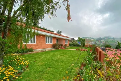 a house with a yard with green grass at Away From Home - 2 - Home Stay Ooty, Entire 4BHK Villa in Ooty
