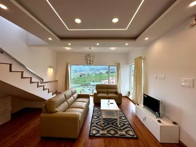 a living room with a couch and a tv at Away From Home - 3 - HomeStay Ooty, Entire 3BHK Villa in Ooty