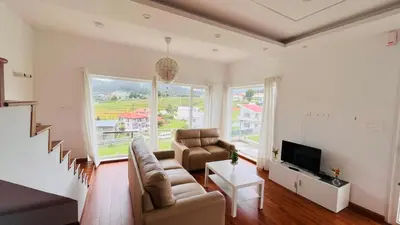 a living room with a couch and a tv at Away From Home - 3 - HomeStay Ooty, Entire 3BHK Villa in Ooty