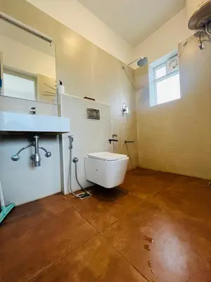 a bathroom with a sink and a toilet and a mirror at Away From Home - 3 - HomeStay Ooty, Entire 3BHK Villa in Ooty