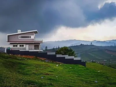 a house on top of a hill on a green field at Away From Home - 3 - HomeStay Ooty, Entire 3BHK Villa in Ooty