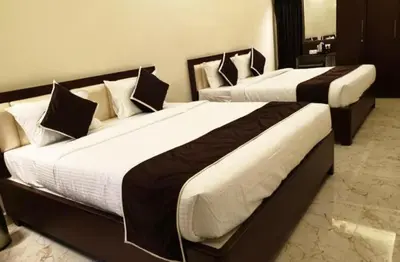 two large beds in a hotel room withskirts at Hotel Saran Palani in Palani