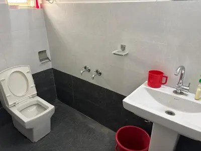 a bathroom with a white toilet and a sink at Heart of Mysore - Entire Place for yourself in Mysore