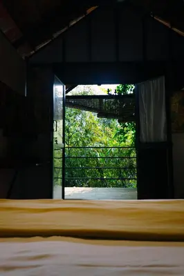 a view of a bed in a room with a window at Little Bricks Reverside Private Pool Villa by GreenEscapes in Vythiri