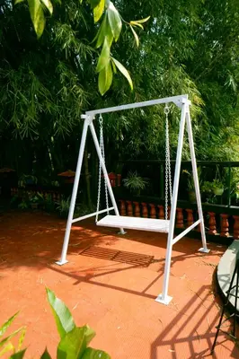 a white swing set sitting on top of a sidewalk at Little Bricks Reverside Private Pool Villa by GreenEscapes in Vythiri