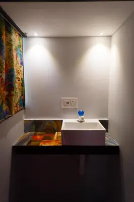 a bathroom with a sink and a painting on the wall at Little Bricks Reverside Private Pool Villa by GreenEscapes in Vythiri