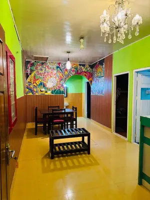 a dining room with a table and a colorful wall at Greenwoods Munnar Unmarried Allowed in Munnar