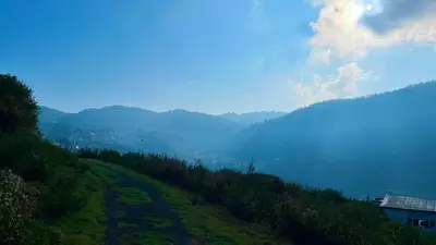a grassy hill with a view of a valley at Away From Home - 1 - Rooms In Ooty, Home Stay Ooty in Ooty