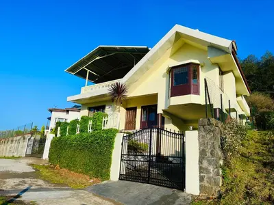 a white house with a black gate in front of it at Away From Home - 1 - Rooms In Ooty, Home Stay Ooty in Ooty