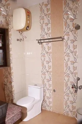 a bathroom with a toilet and a shower at Greenyard cottage in Ooty