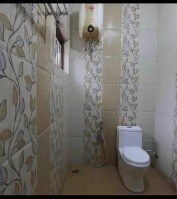 a bathroom with a toilet and a shower curtain at Greenyard cottage in Ooty