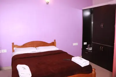 a bedroom with a bed and a purple wall at Greenyard cottage in Ooty