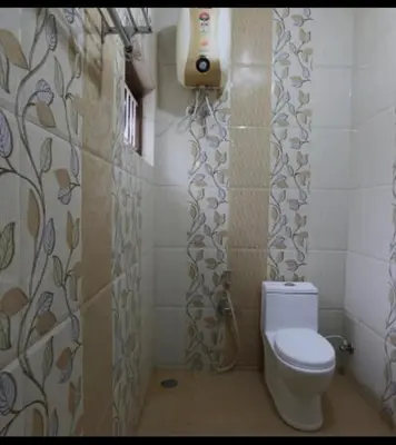 a bathroom with a toilet and a shower curtain at Greenyard cottage in Ooty