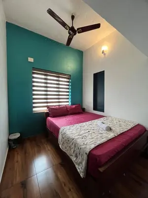 a bedroom with a large bed with a ceiling fan at Dragster Pool Villa in Māla