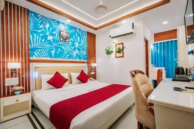 a hotel room with a bed and a desk at Excellency Airport Hotel in Ernakulam
