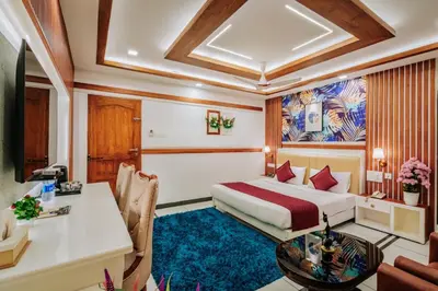 a hotel room with a bed and a desk at Excellency Airport Hotel in Ernakulam