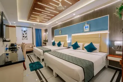a hotel room with two beds and a couch at Excellency Airport Hotel in Ernakulam