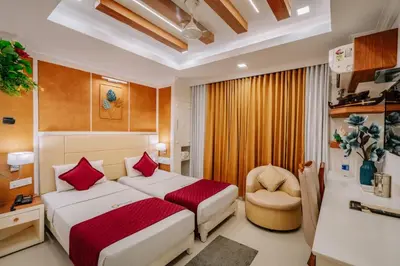 a hotel room with a bed and a chair at Excellency Airport Hotel in Ernakulam