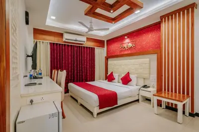 a bedroom with a bed and a desk in a room at Excellency Airport Hotel in Ernakulam