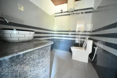a bathroom with a sink and a toilet at Kashi's stay in Kushālnagar