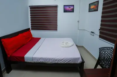 a bedroom with a bed with red and white sheets at Hr residency in Kozhikode