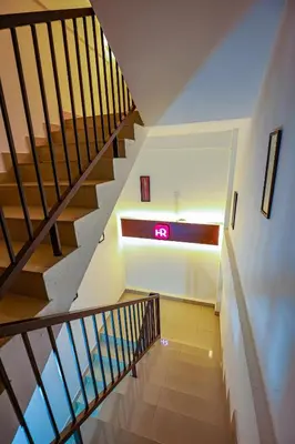 a staircase in a house with a clock on the wall at Hr residency in Kozhikode