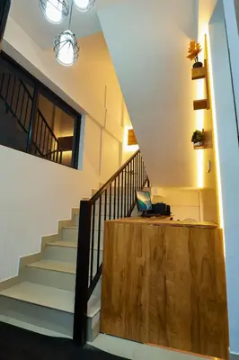 a staircase with a laptop on a desk in a house at Hr residency in Kozhikode