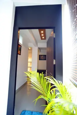 a hallway with a mirror and a plant at Hr residency in Kozhikode