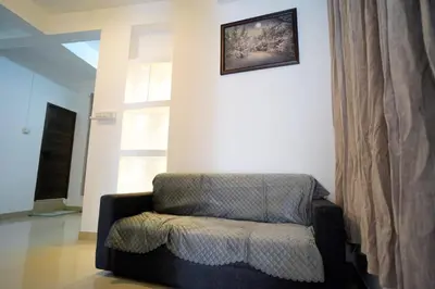 a chair in a living room with a picture on the wall at Hr residency in Kozhikode