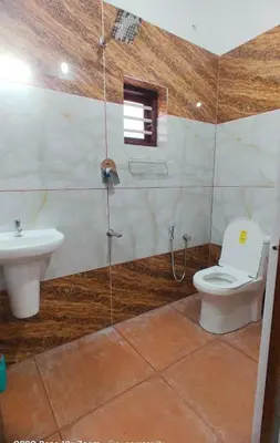 a bathroom with a toilet and a sink at Karukutty Rental House in Adūr