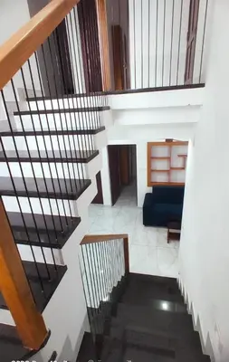 a spiral staircase with a blue couch in a room at Karukutty Rental House in Adūr