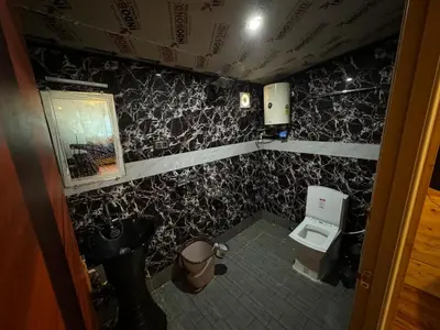 a small bathroom with a toilet and a sink at Fairyland Resort in Kodaikānāl