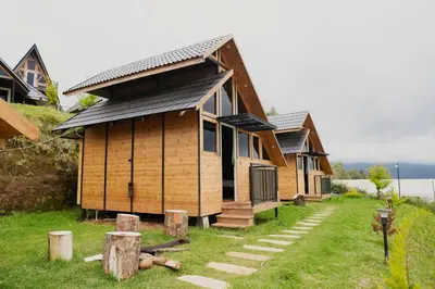 a row of cottages in a yard with grass at Fairyland Resort in Kodaikānāl