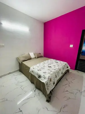 a bed in a room with a pink wall at In-woods stay in Olavakod Junction
