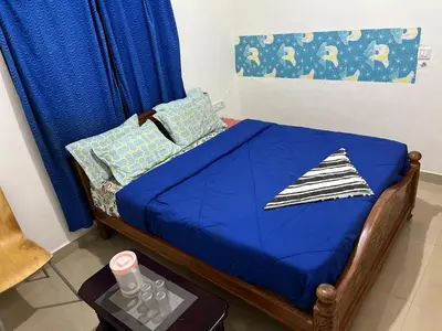 a small bed with blue sheets and pillows on it at Chillz Heaven Resorts - Ketti Palada in Coonoor