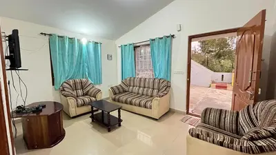 a living room with two chairs and a television at Chillz Heaven Resorts - Ketti Palada in Coonoor